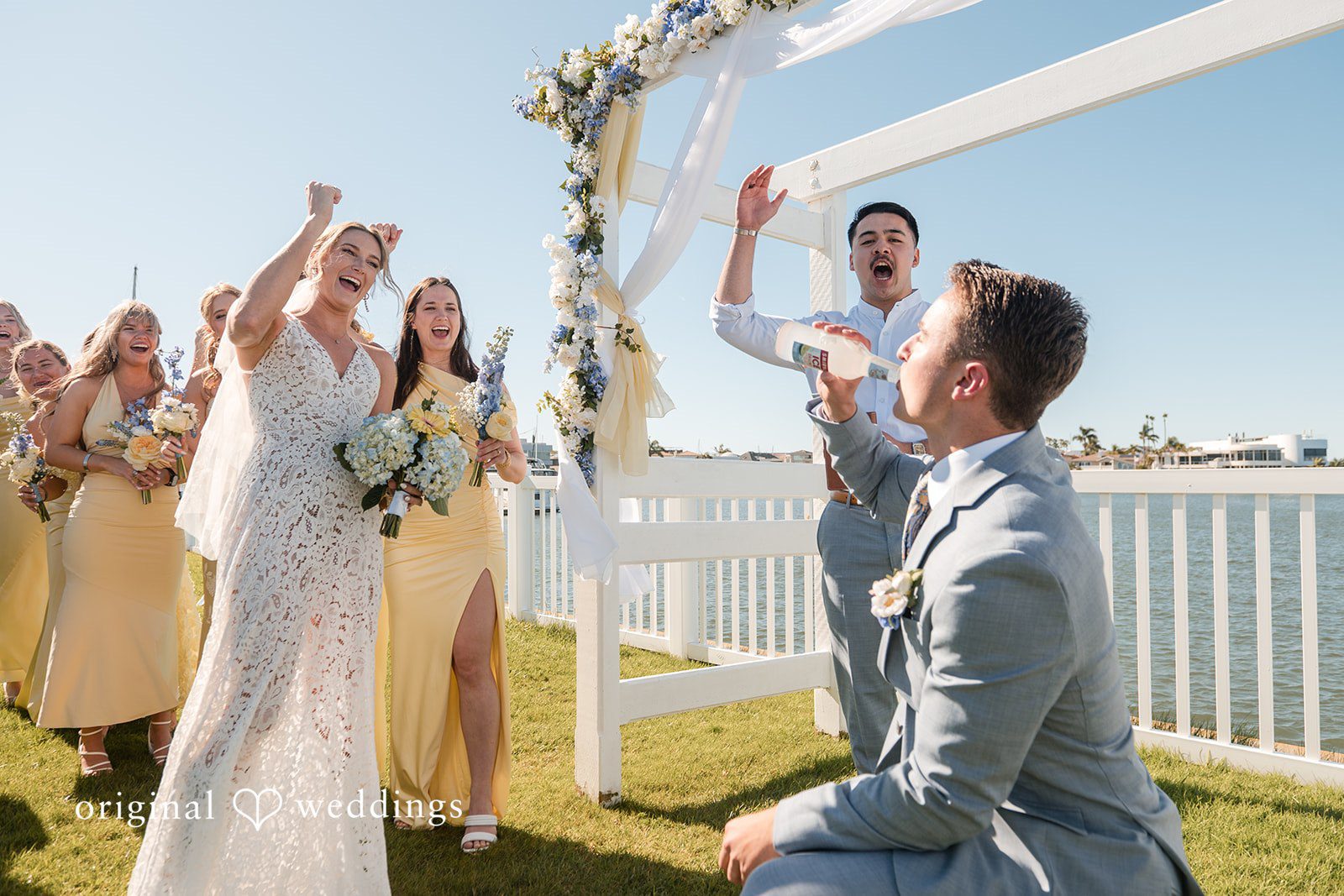 Bride and groom sharing joyful moment during waterfront ceremony