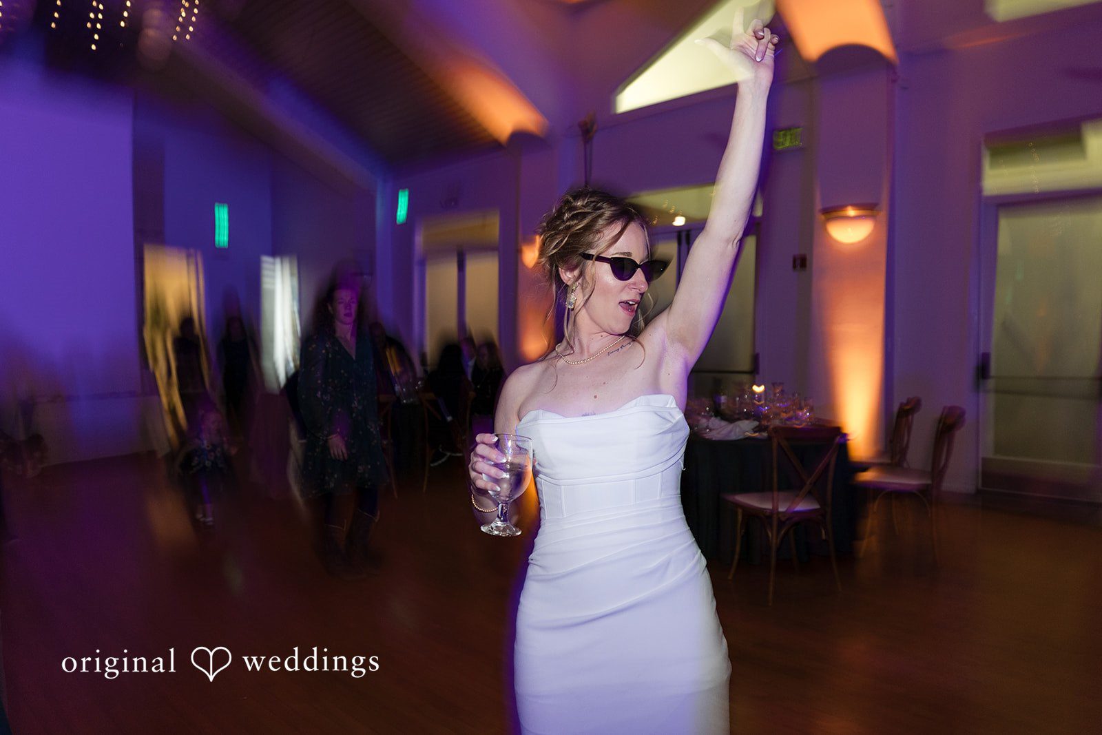 Bride celebrating on a brightly lit dance floor.