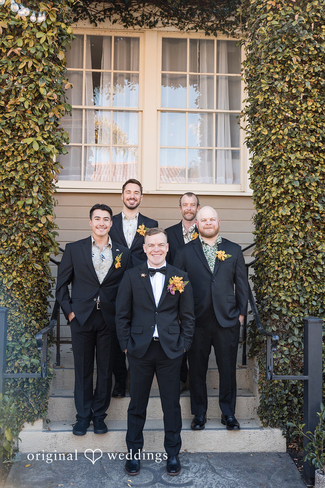 Groom and groomsmen posing together in black tuxedos at Cuvier Club by Wedgewood Weddings.