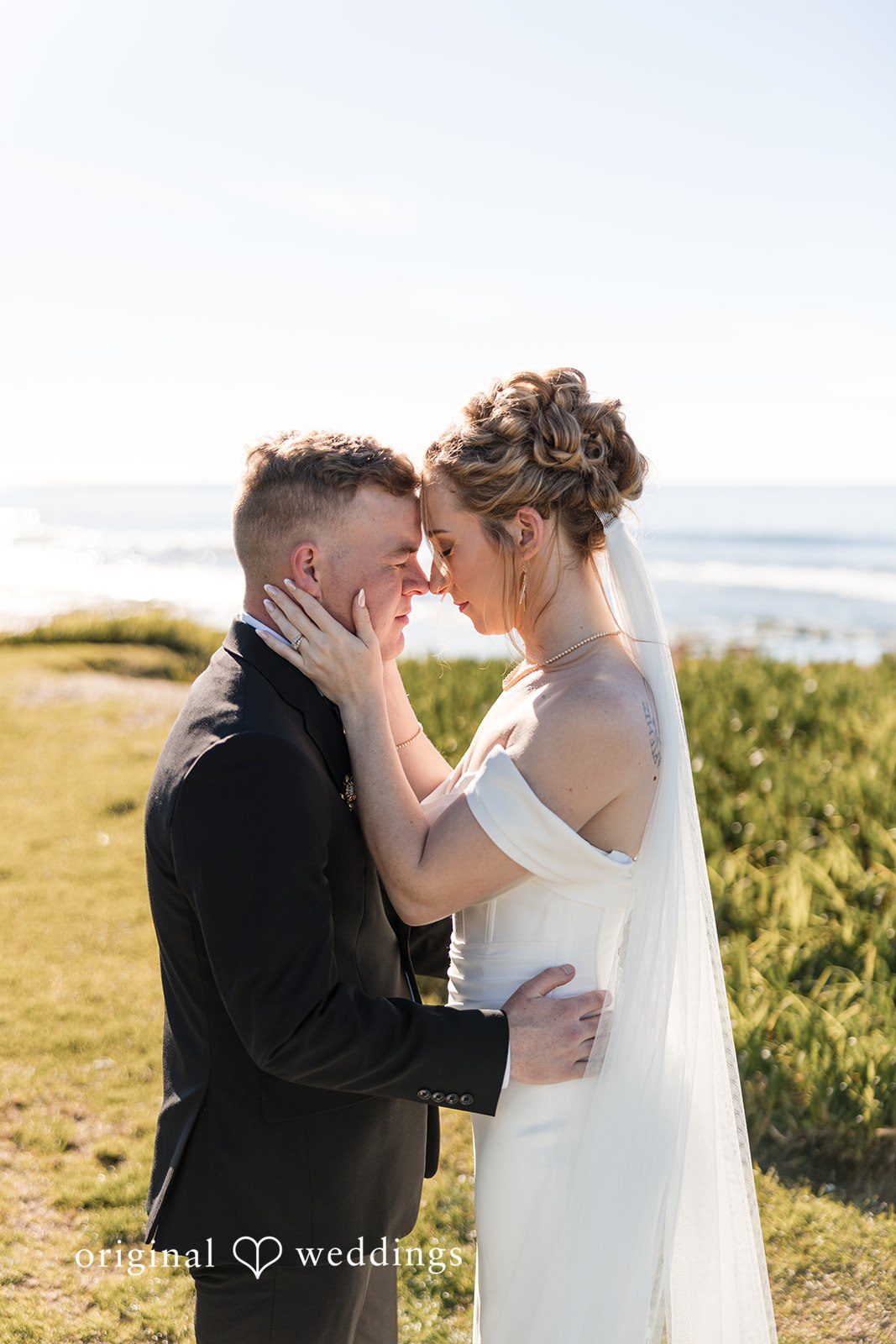 Close-up of a bride and groom embracing face-to-face.