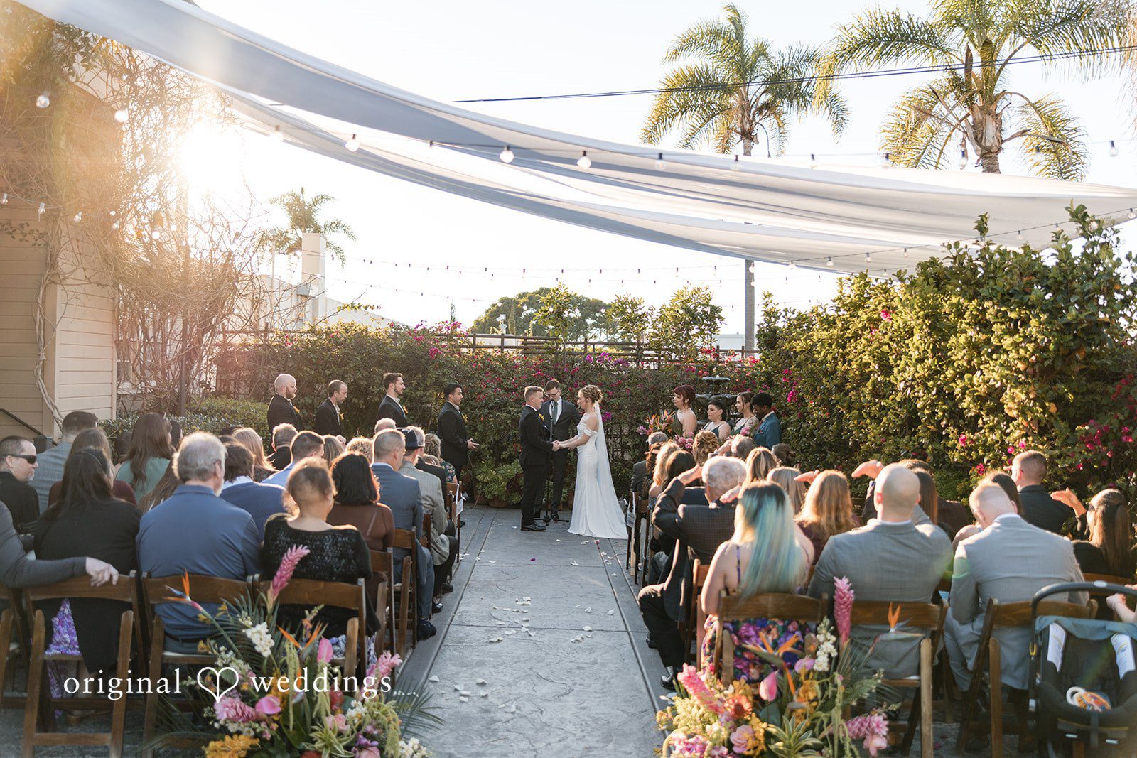 Seated wedding guests facing the altar during a ceremony.