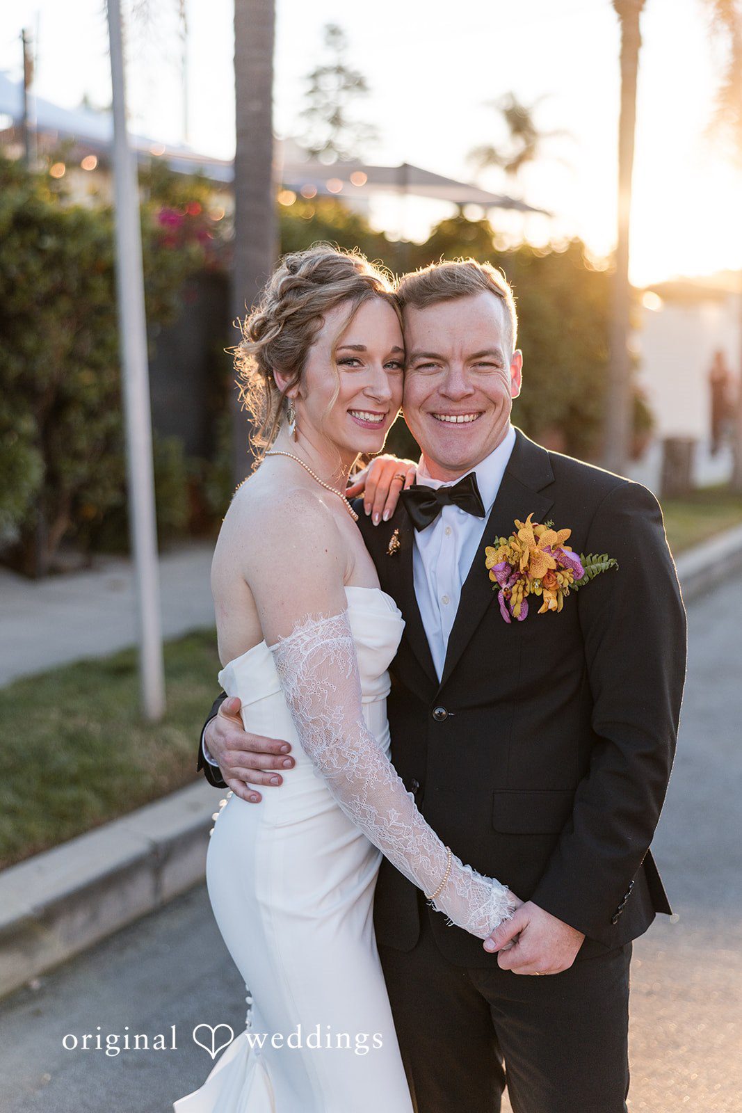 Bride and groom smiling together at sunset.