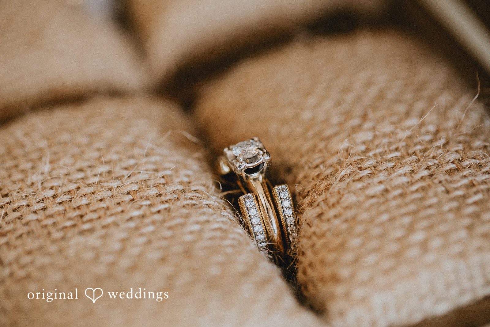 Catalyna + Nik Wedding rings displayed on textured fabric