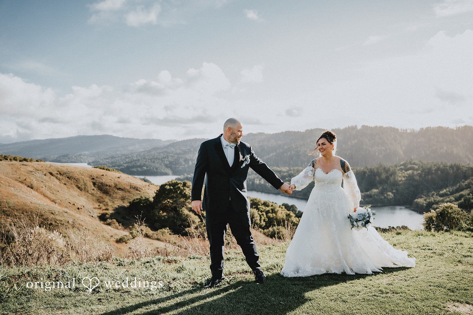 Dominique + Chris Bride and groom holding hands on a mountain overlook