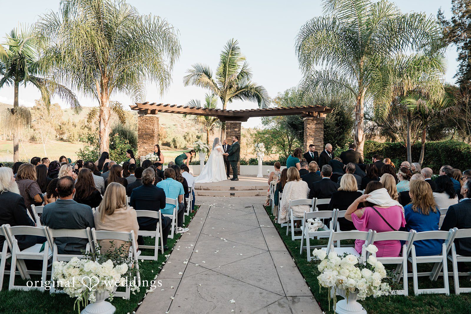 Jinelle + Brett Wedding couple sharing a loving moment while holding hands outdoors at Fallbrook Estate