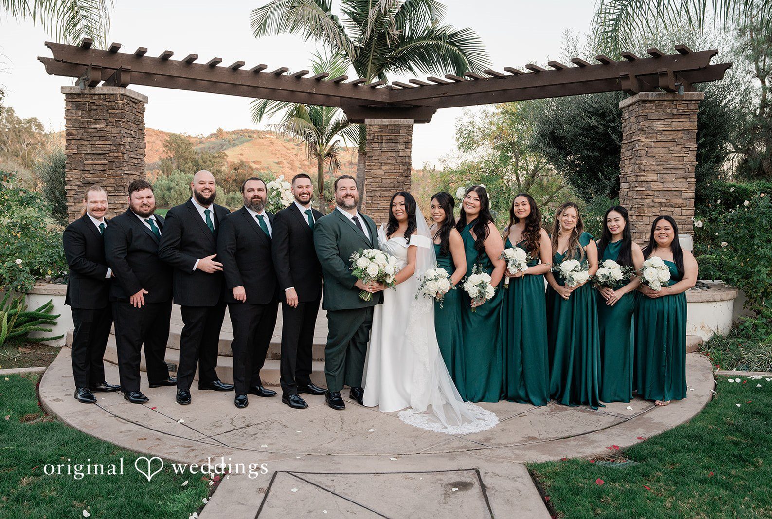 San Diego wedding photography by Original Weddings capturing bride and groom posing with bridesmaids and groomsmen during elegant wedding at Fallbrook Estate