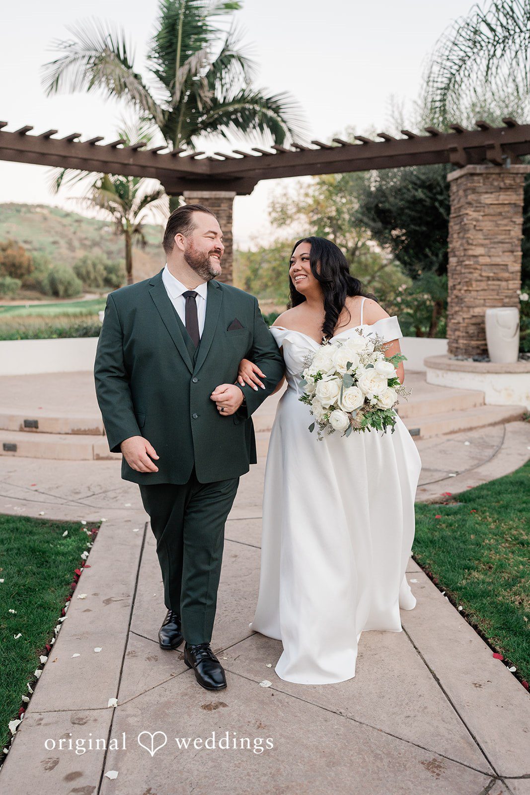 Jinelle + Brett San Diego Wedding Photography by Original Weddings capturing Romantic bride and groom walking together with elegant white wedding bouquet at Fallbrook Estate