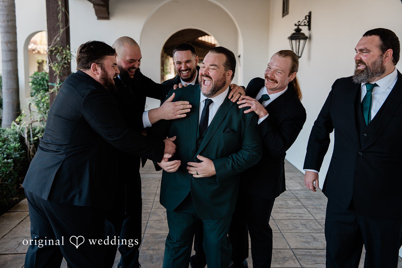 Jinelle + Brett Groom with groomsmen posing together before wedding ceremony with joyful expressions