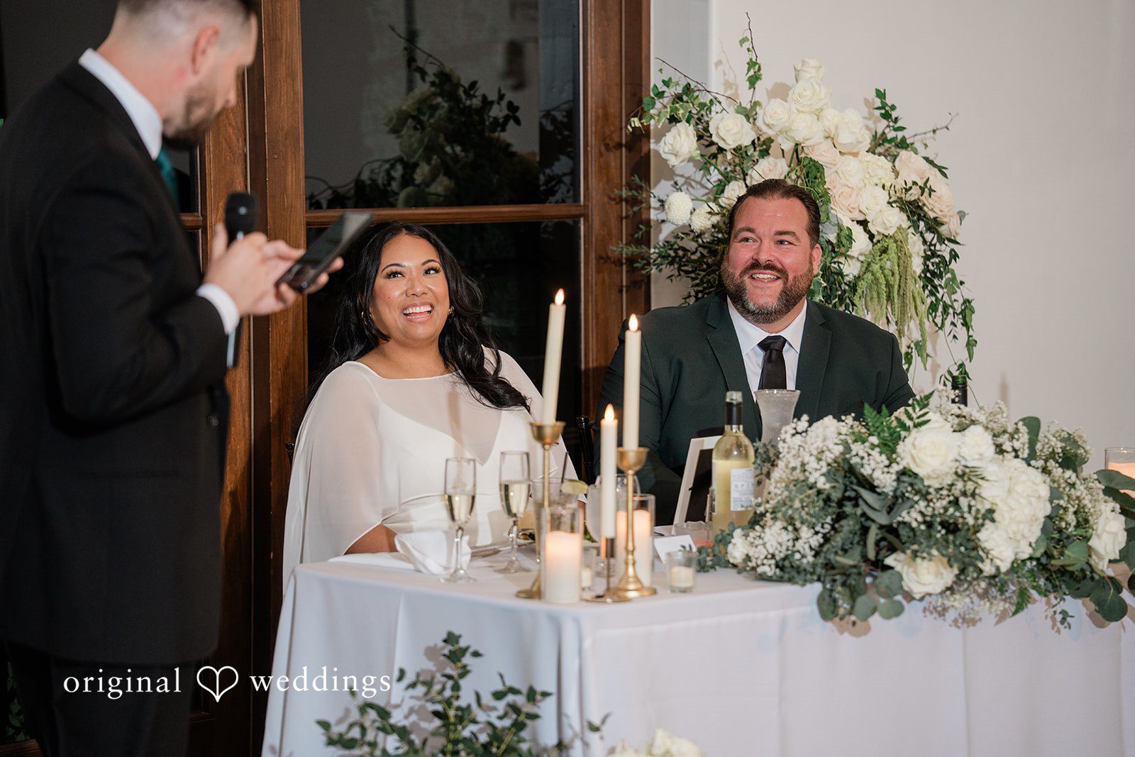 Jinelle + Brett Emotional wedding reception toast with bride and groom surrounded by elegant floral decor