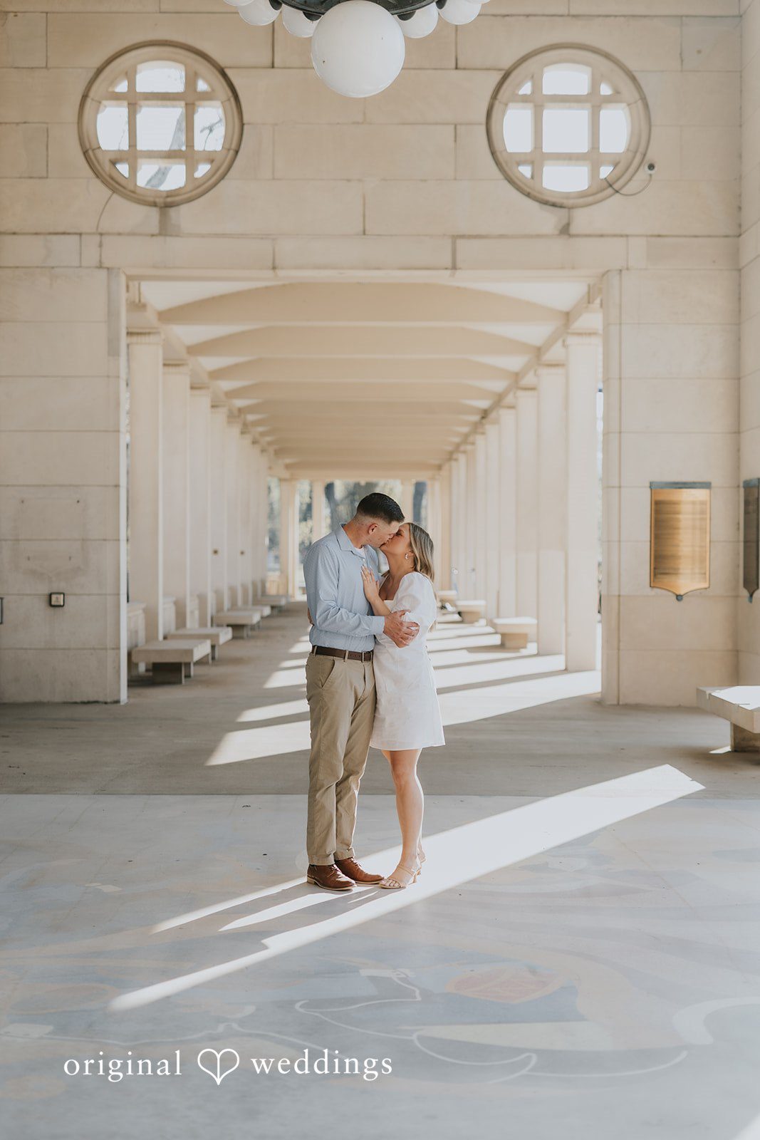 The couple shares a kiss at the walkway at Forest Park