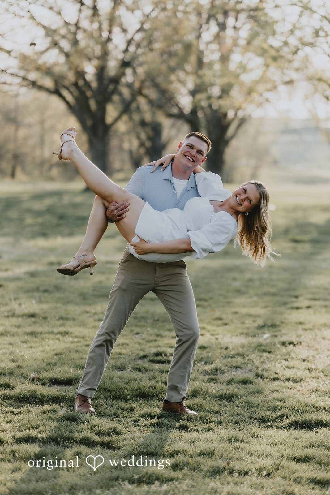 The groom happily lifts the bride