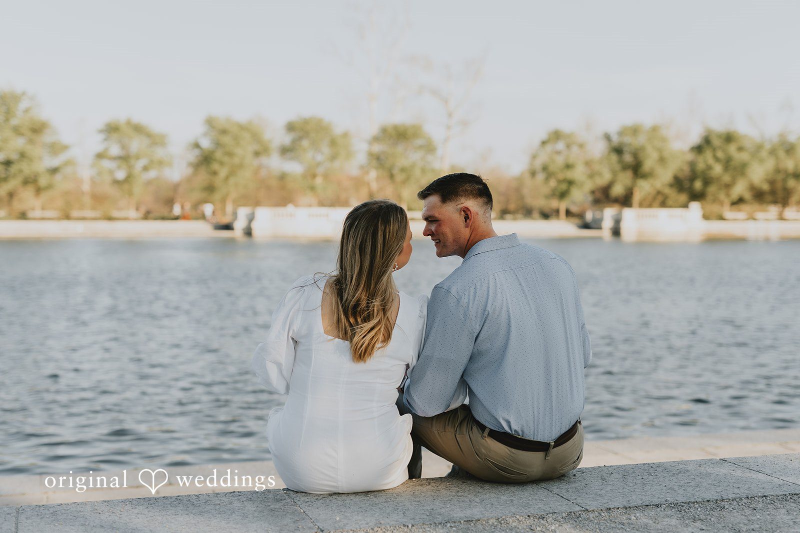 The couple seated by the waterfront