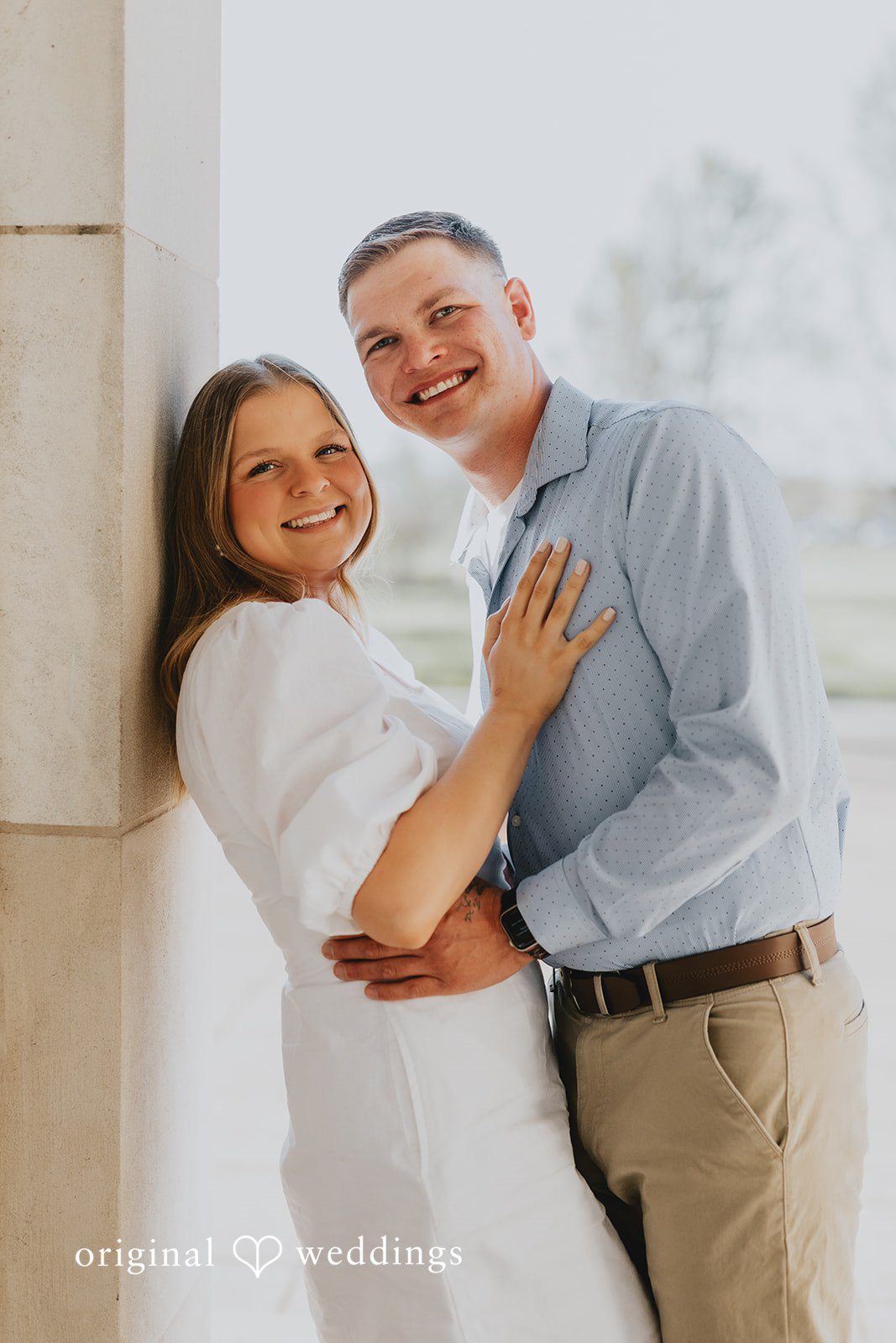 The couple smiles at the camera