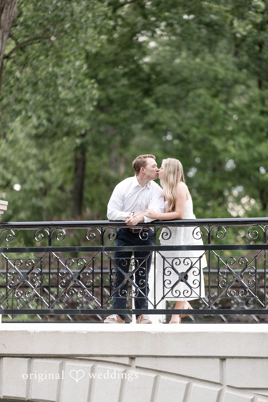Rhyen + Jacob Wide engagement portrait of the couple standing on a bridge