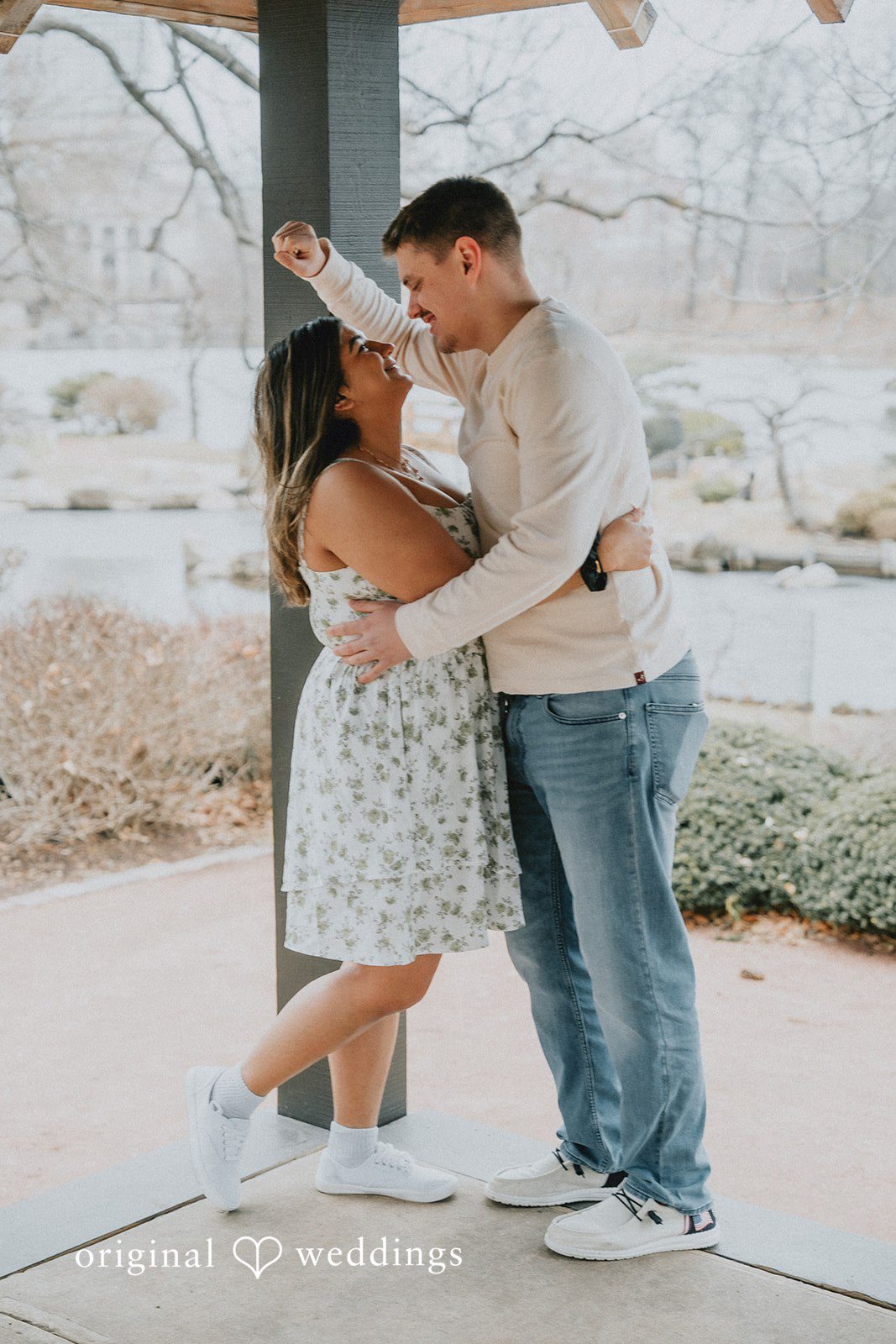 Couple smiling together under a pavilion.