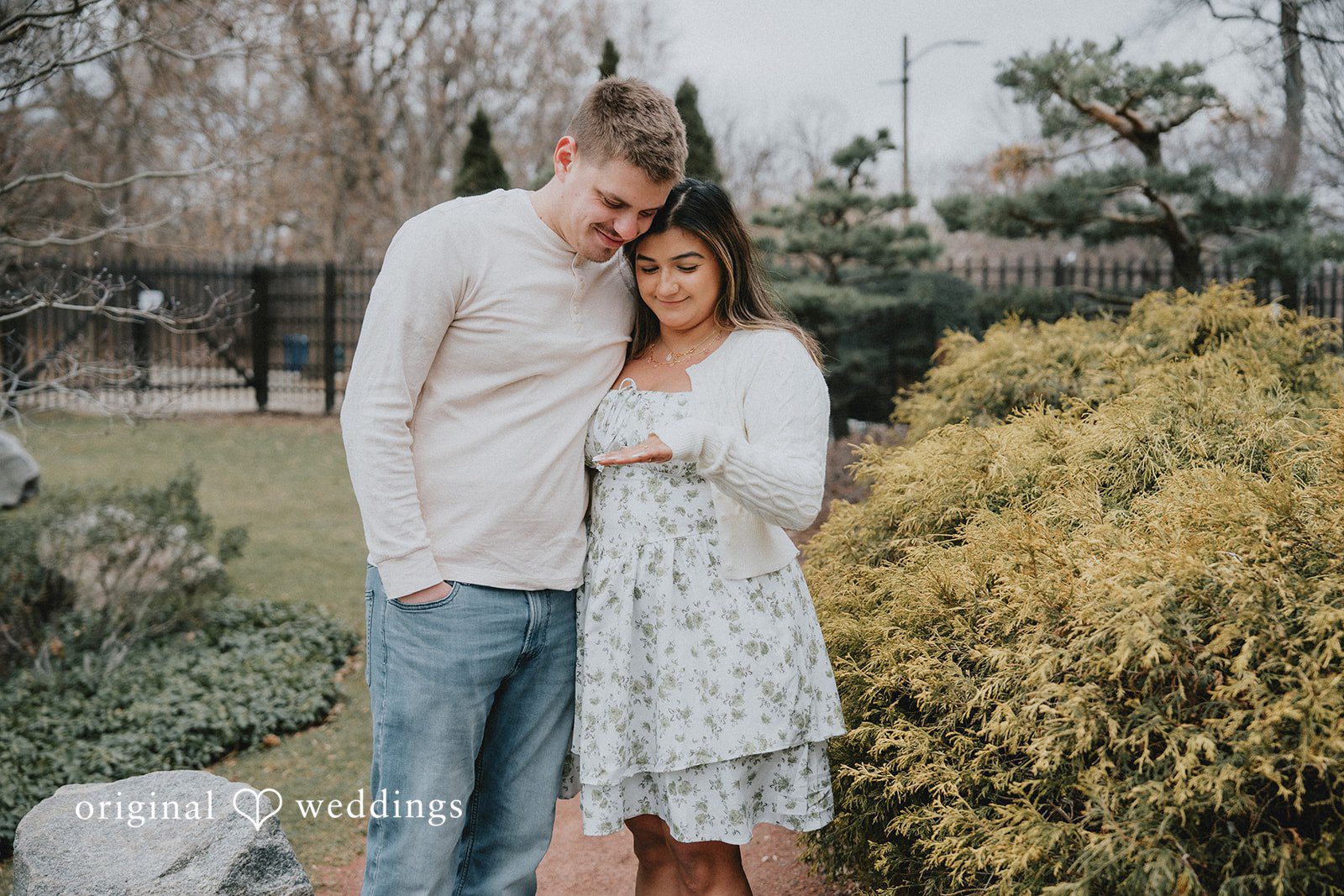 Couple standing close together while looking at engagement ring