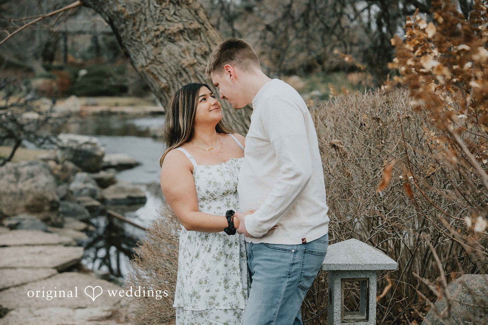 Couple posing closely with soft smiles.