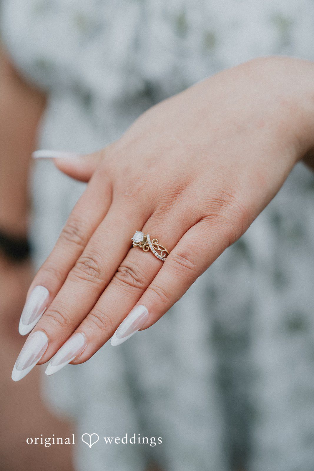 Close-up of a hand wearing an engagement ring.