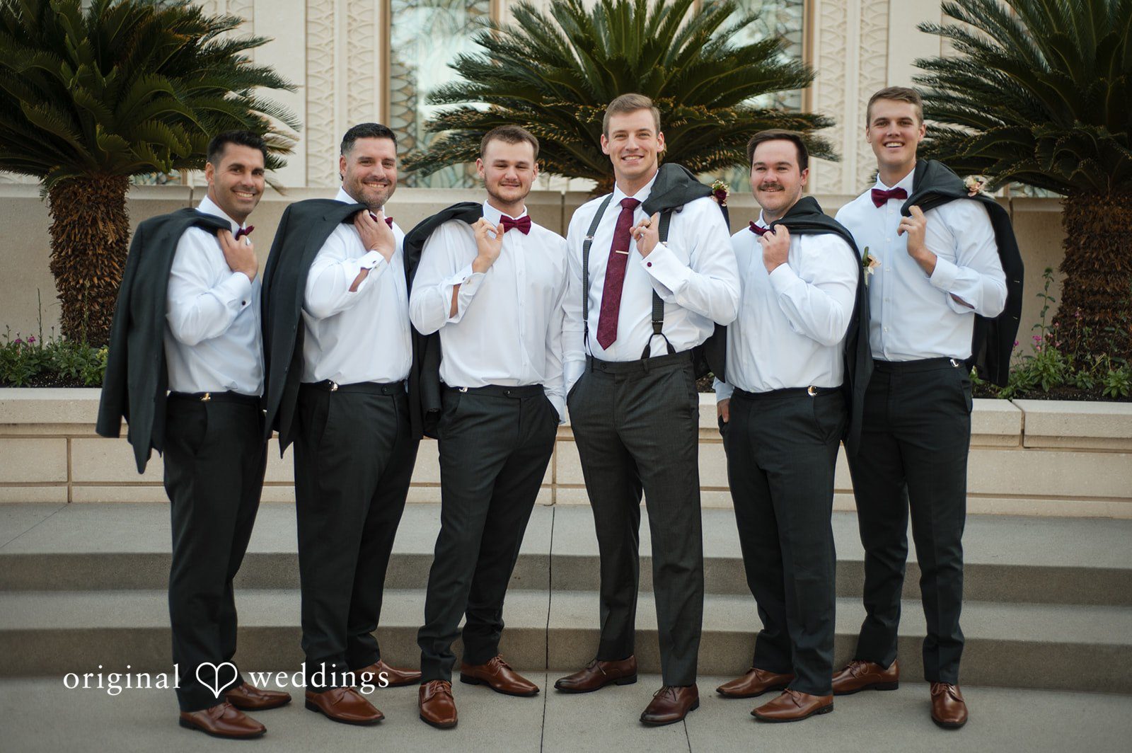 Groom posing with groomsmen outside the venue