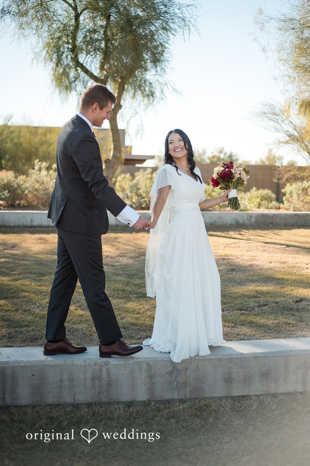 Bride and groom walking together during outdoor wedding portraits
