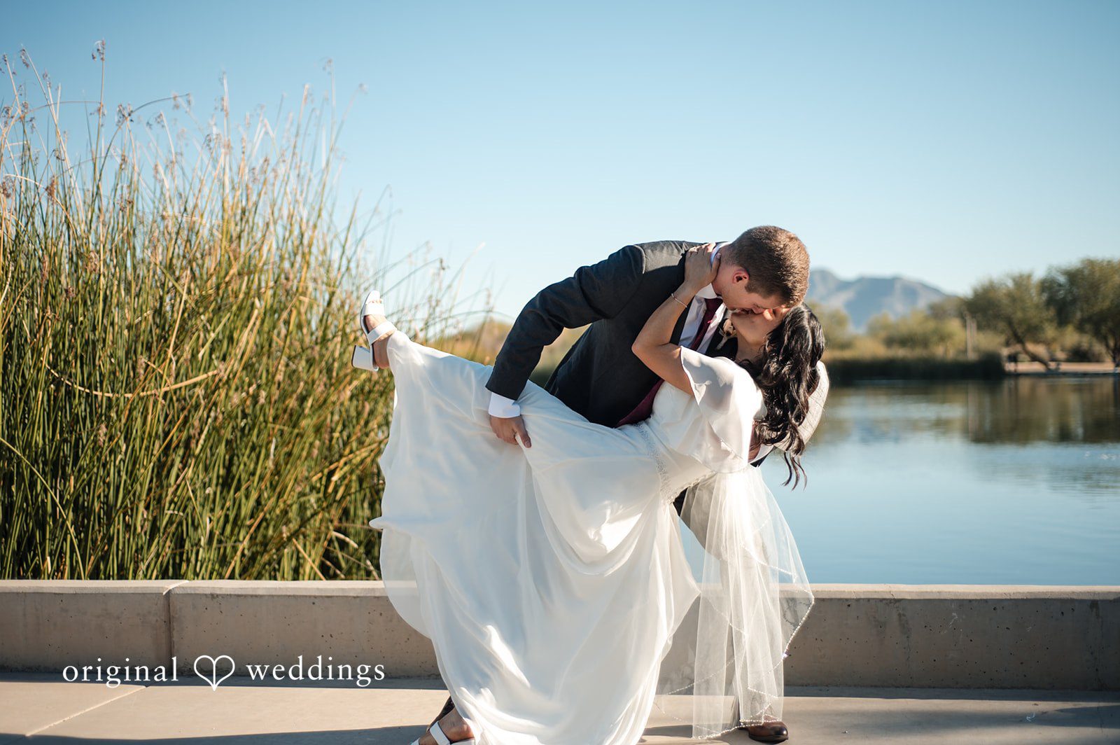 Bride and groom sharing their first kiss outdoors with scenic views