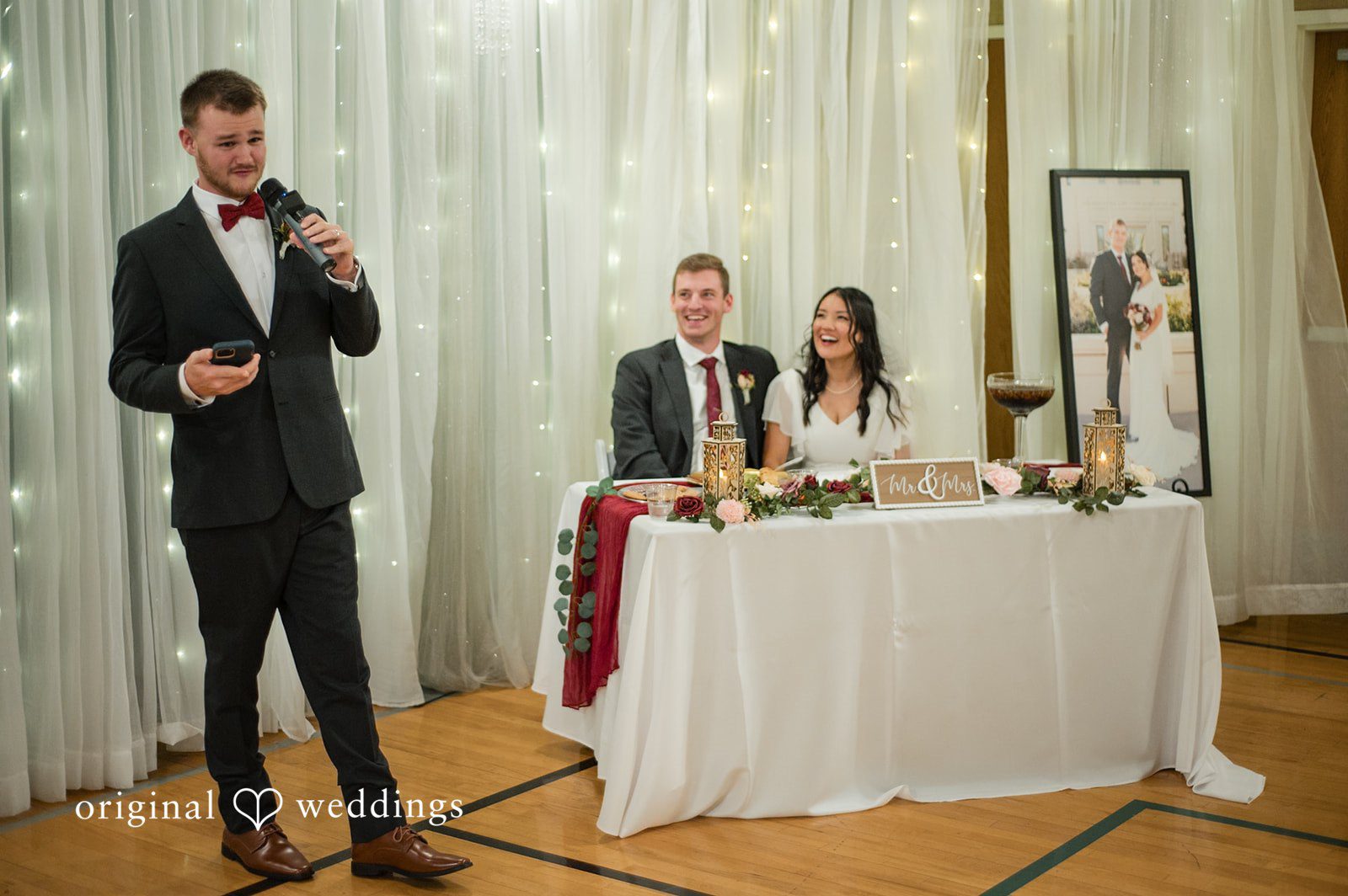 Bride and groom seated at their table listening to speeches
