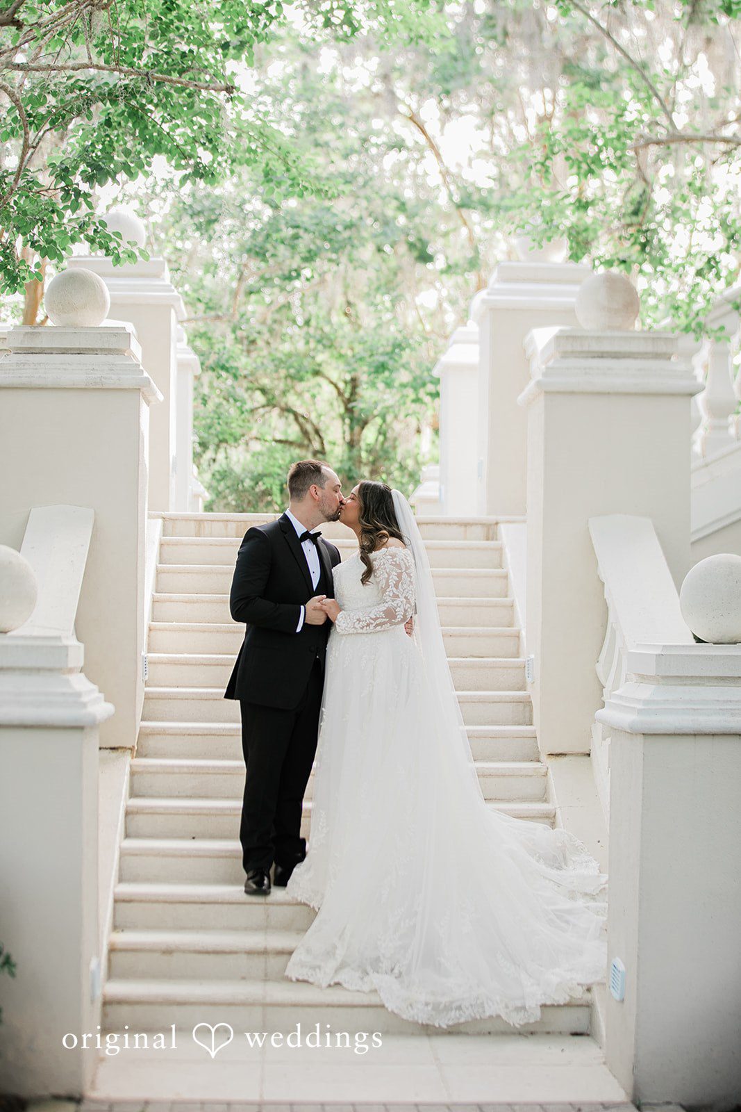 The couple shares a kiss by the stairs