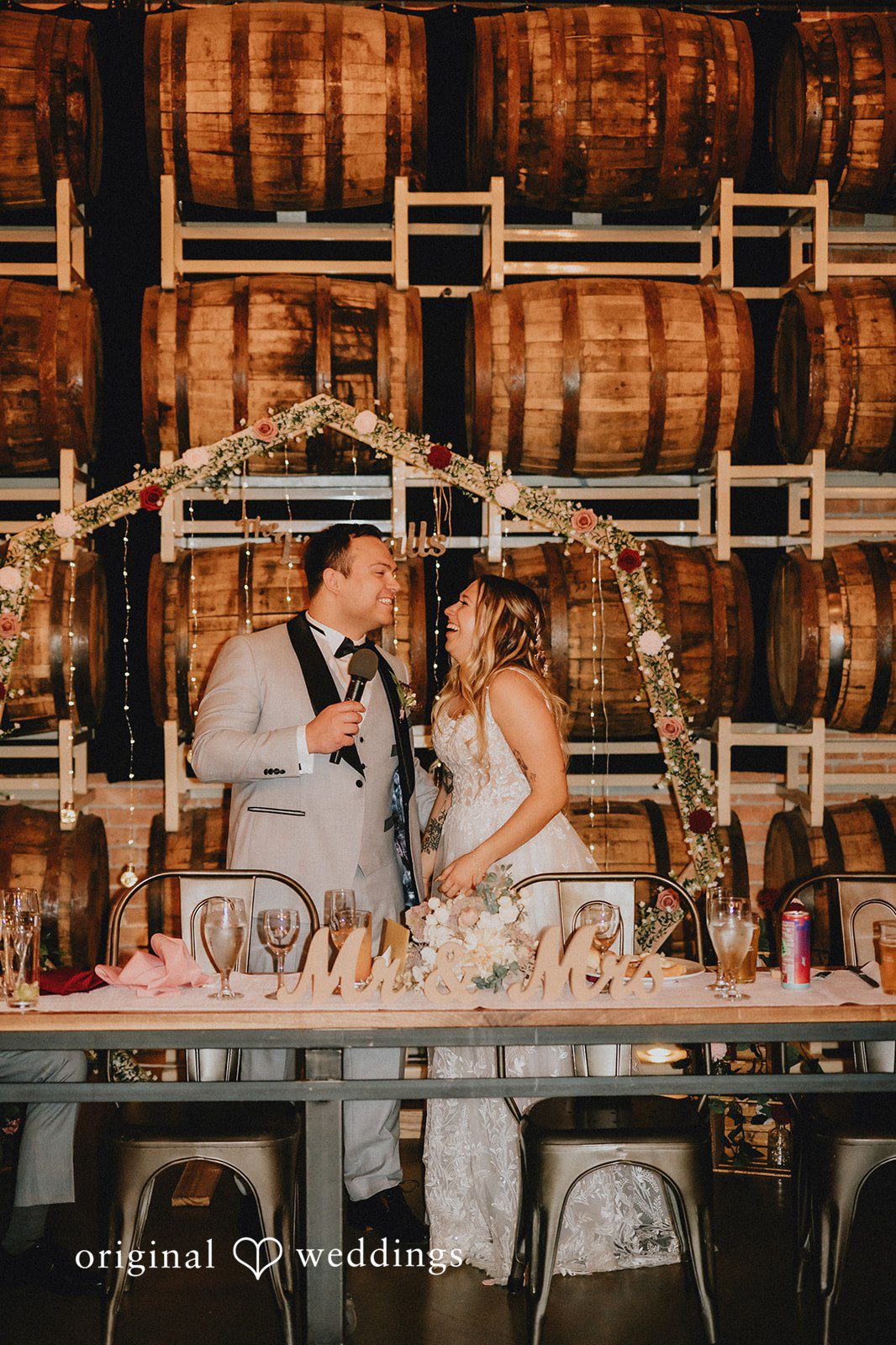 The couple laughs happily at their wedding reception