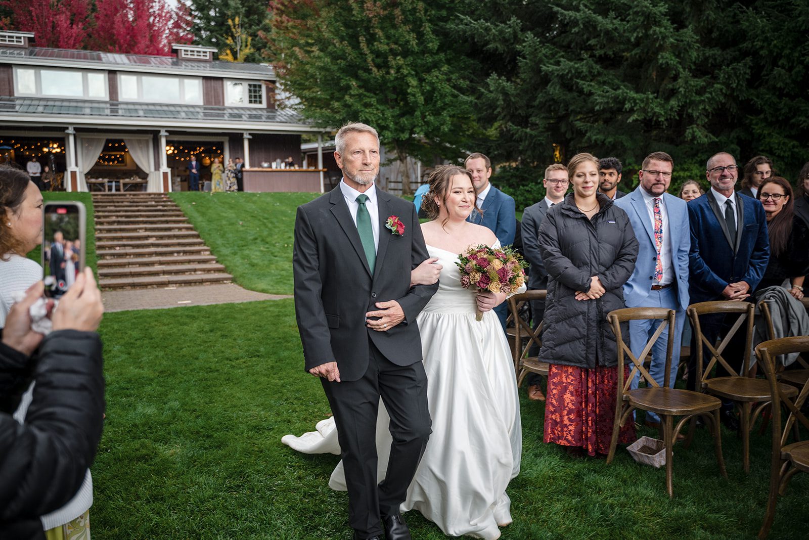 Tiare + Jeremy Bride carrying bouquet while walking down the aisle at vineyard wedding