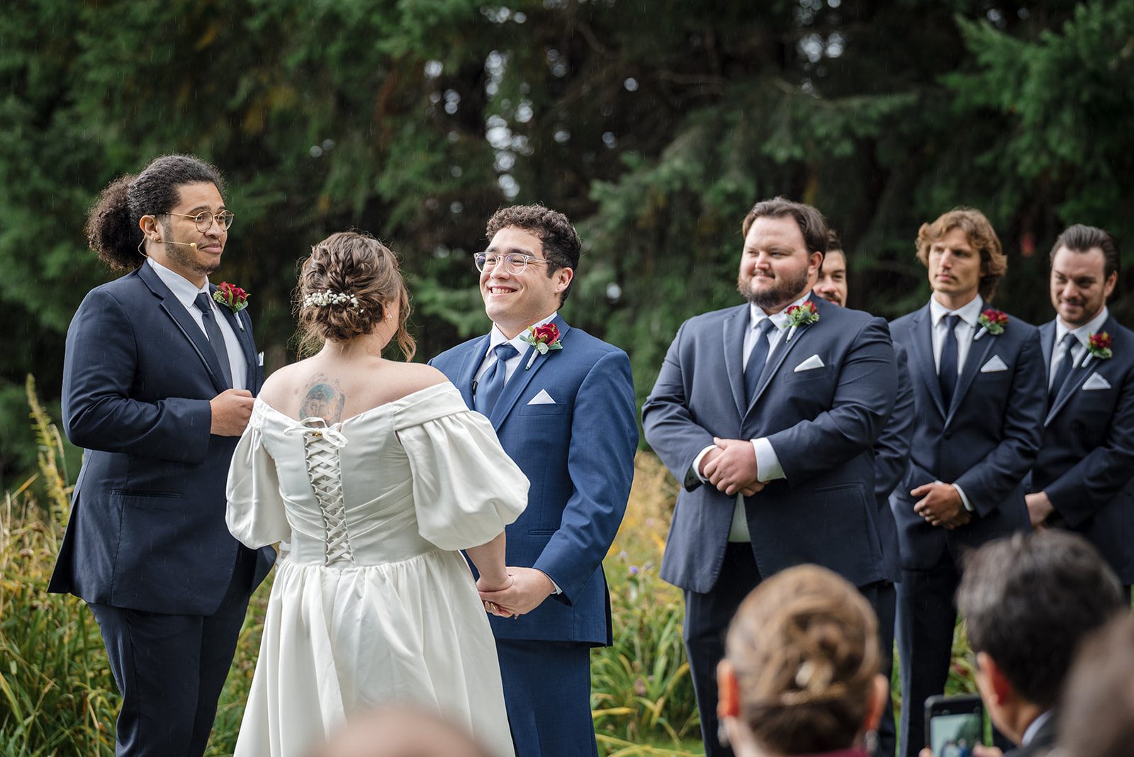 Tiare + Jeremy Bride carrying bouquet while walking down the aisle at vineyard wedding