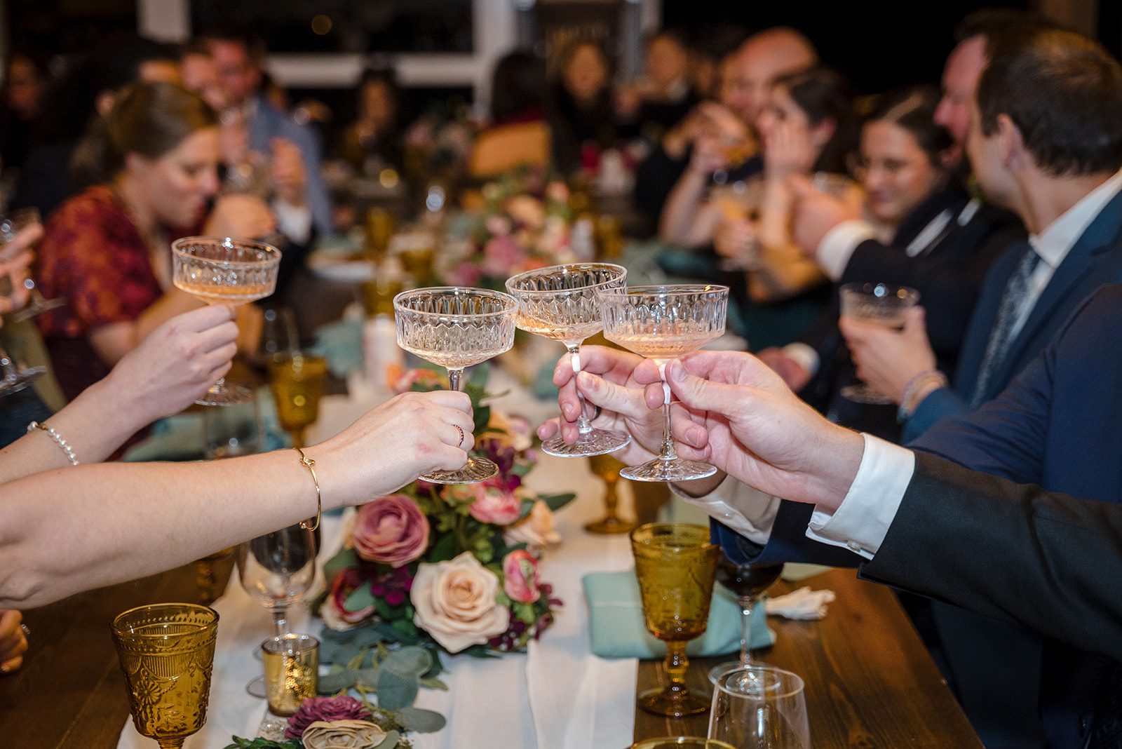 Tiare + Jeremy Wedding dinner toast moment featuring elegant glassware and joyful guests celebrating together