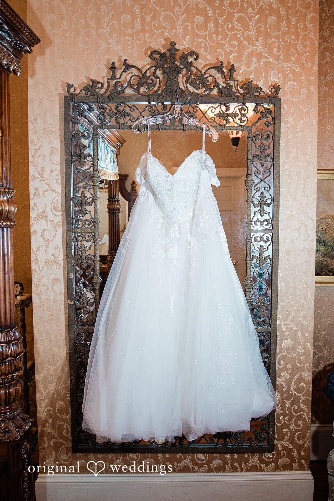 Nicole + Greg The bride's wedding gown hangs gracefully at the suite