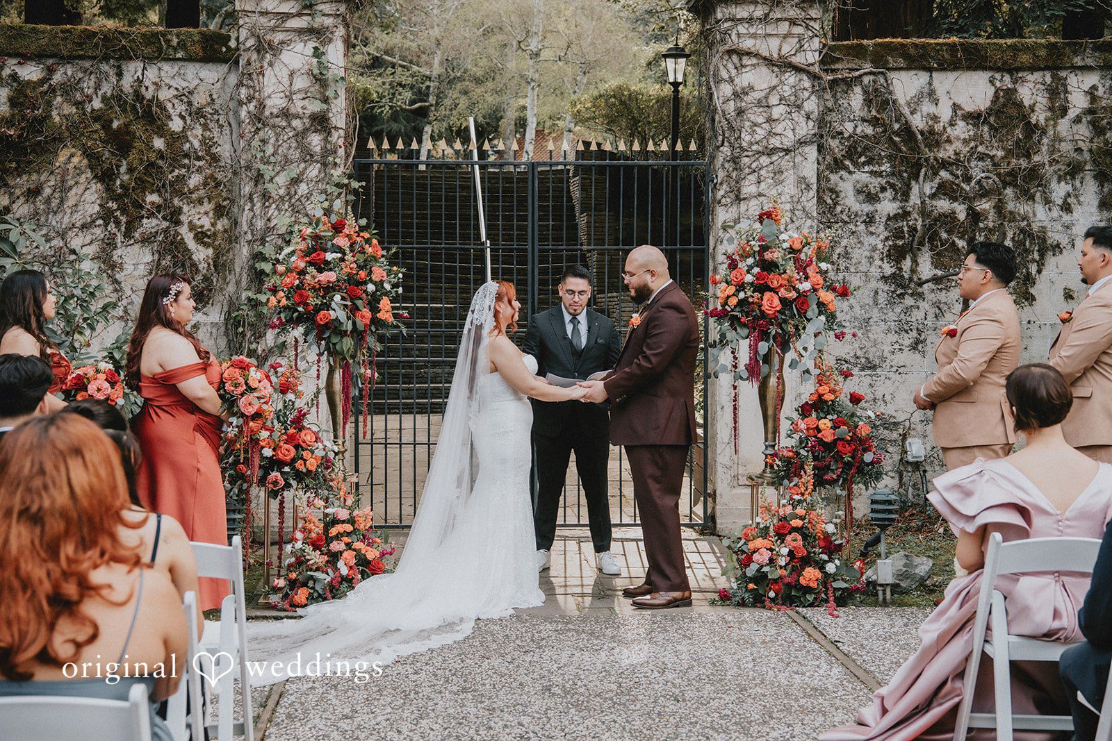 Couple standing in front of priest holding each others hands