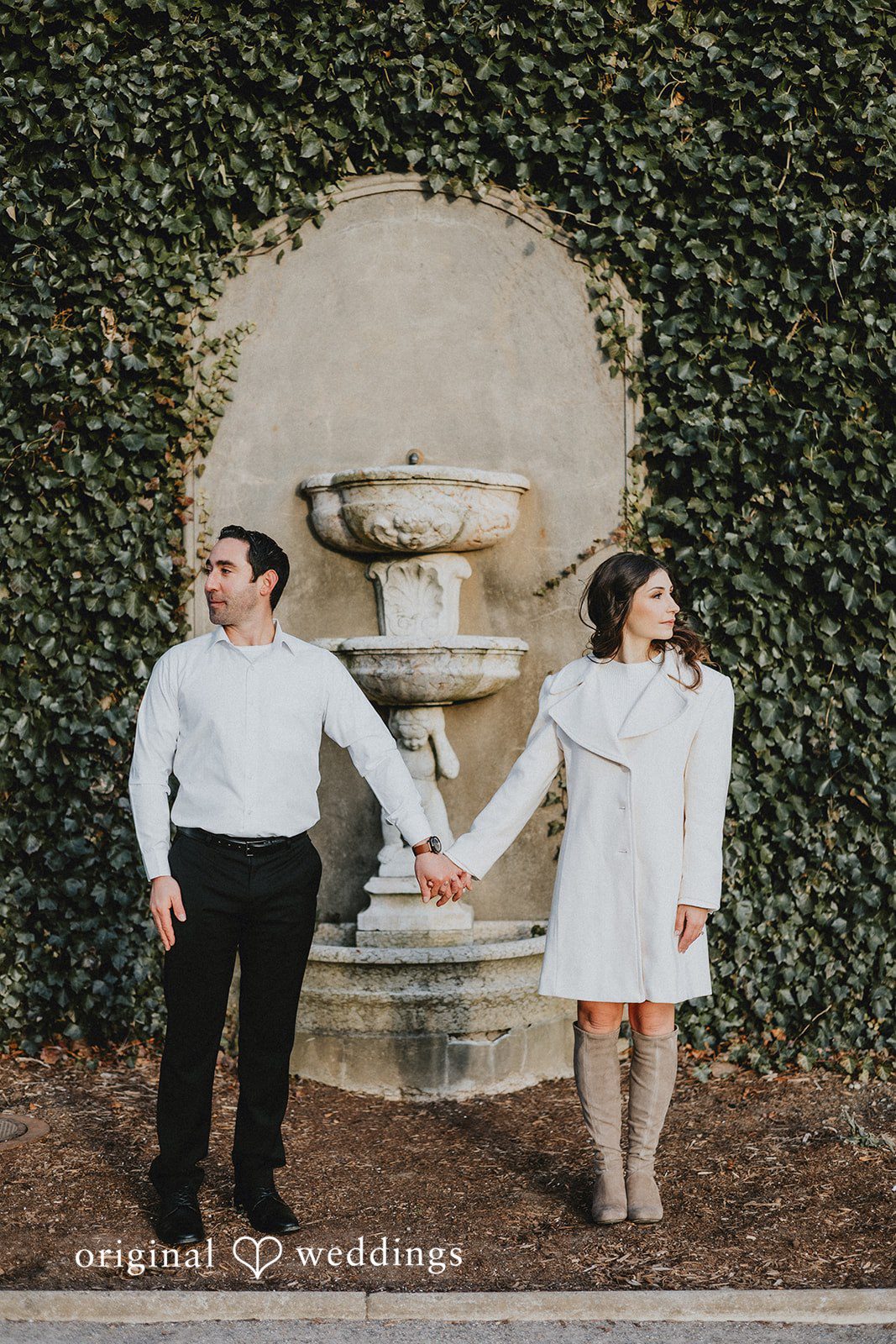 A portrait of the couple framed by art and greenery at the engagement venue