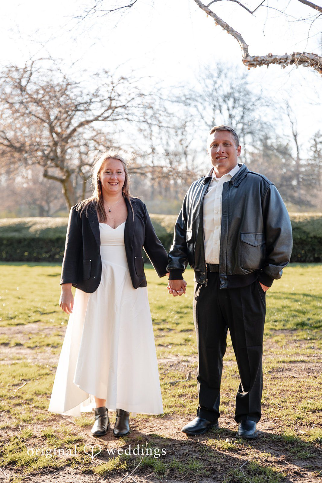 Romantic couple standing together holding hands during engagement session at Holcomb Gardens
