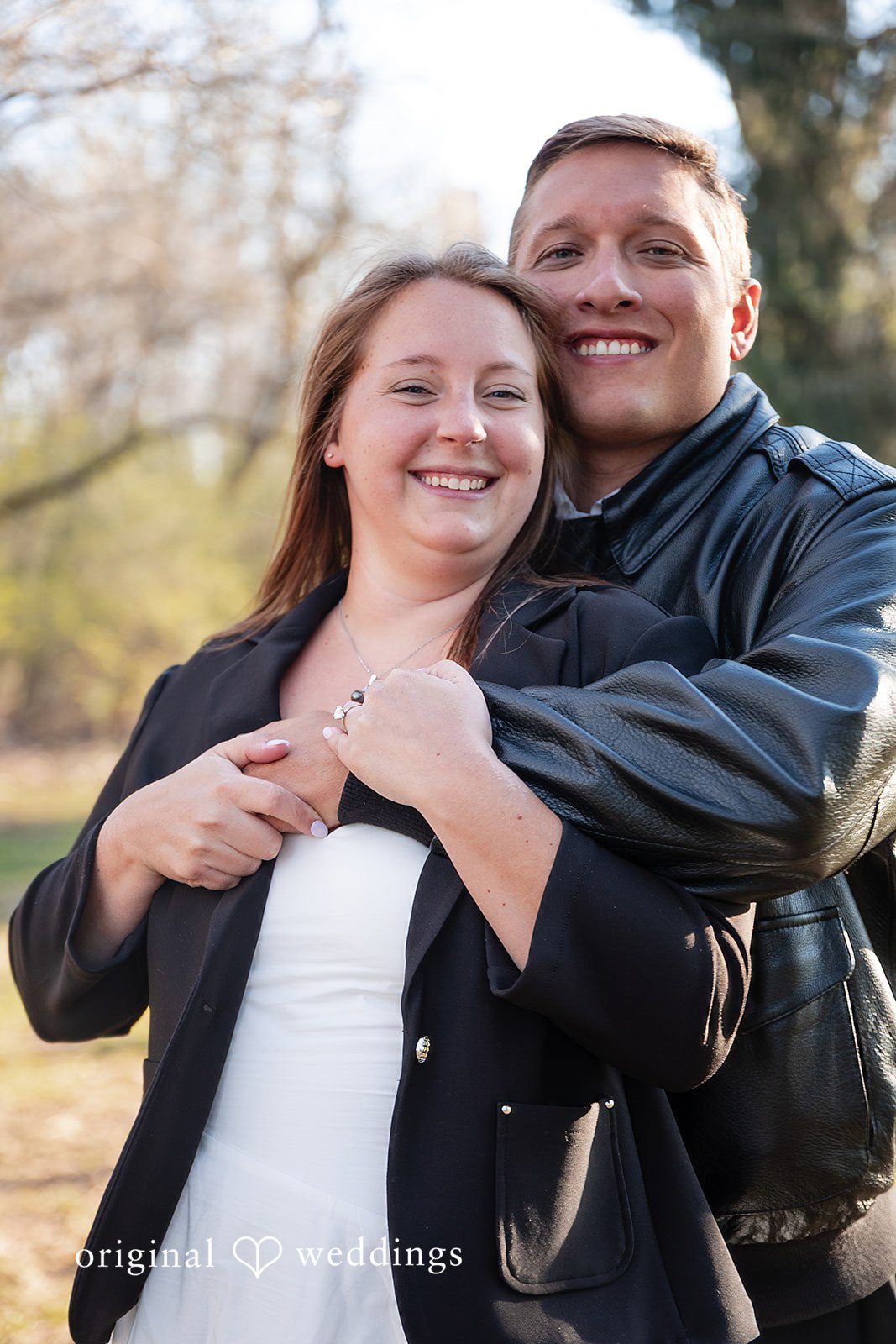 Joyful and affectionate couple moment with groom hugging bride from behind