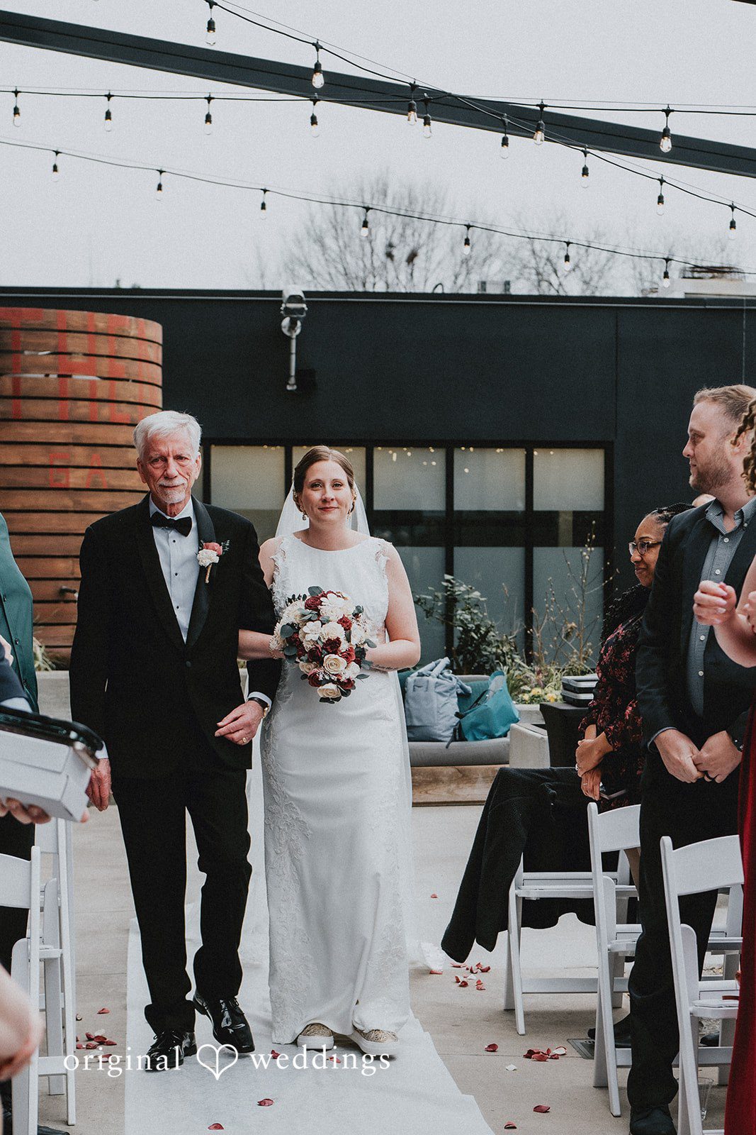 Bride coming in aisle with man.