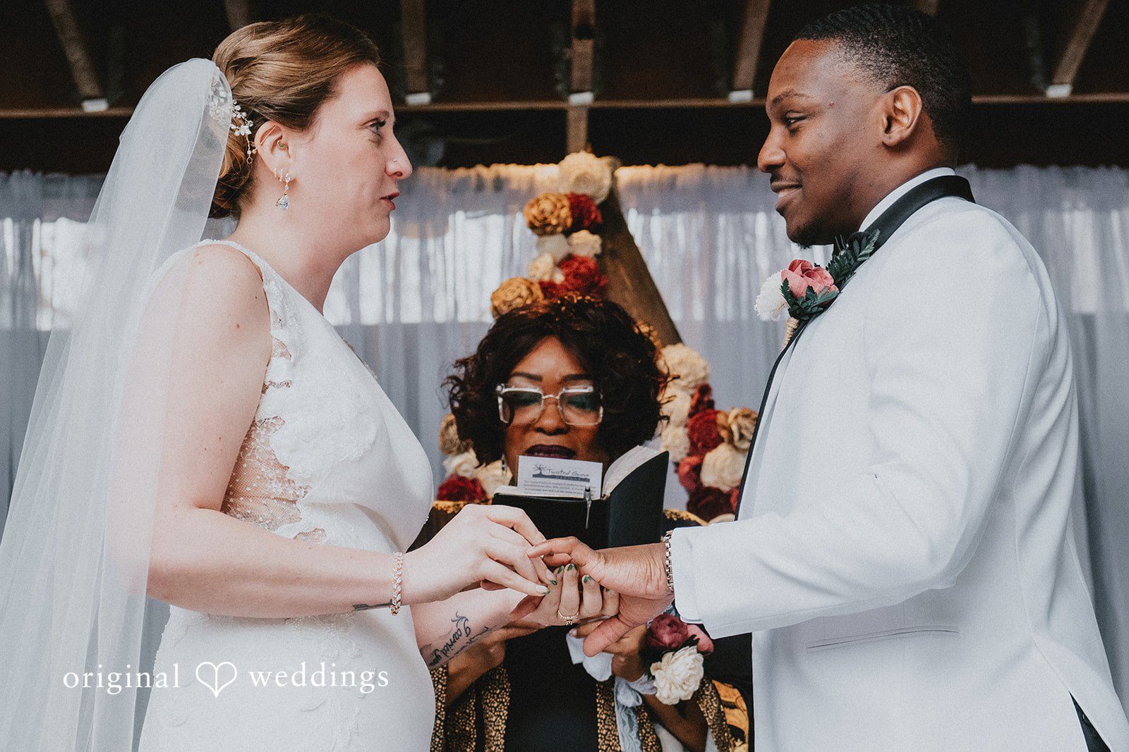 A close-up of the couple’s hands during the ring exchange at the altar.