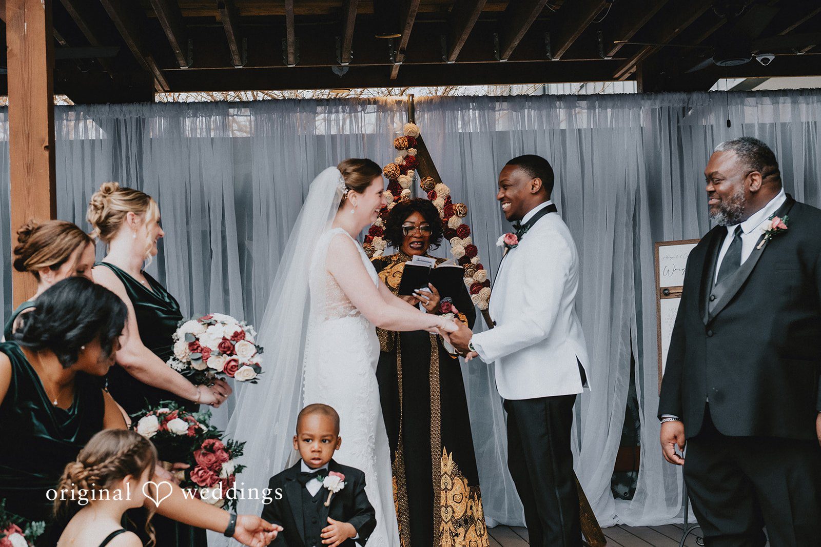 The couple standing at the altar with their wedding party during the ceremony.