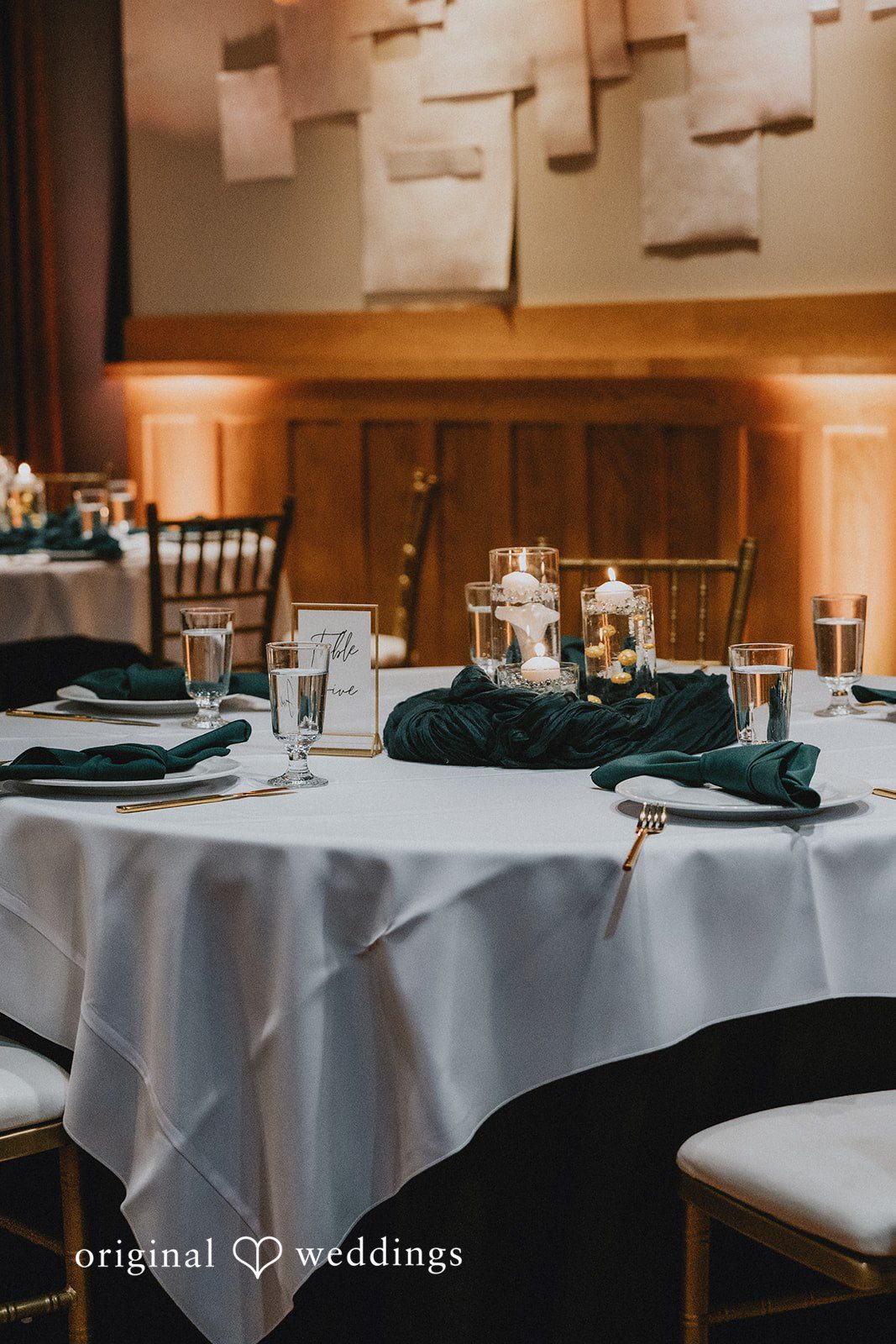 A round table with a white tablecloth, set with black napkins and glassware at Hotel Indigo Athens.