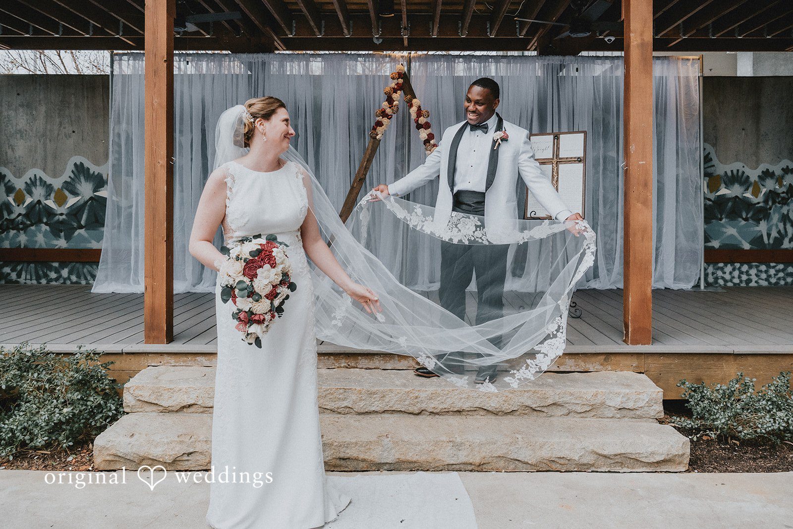 Groom holding the veil of bride