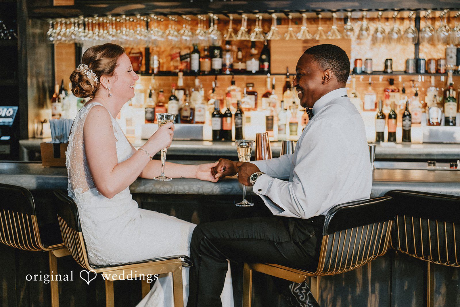 The bride and groom sitting together at a modern bar, sharing a private moment..