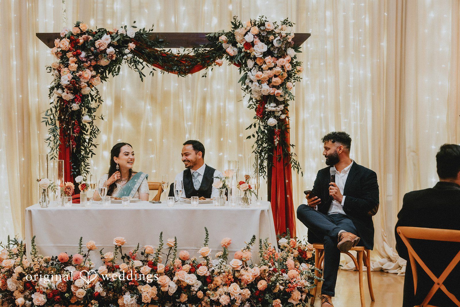 Chandrakant + Sumbul Bride and groom seated together at their reception table