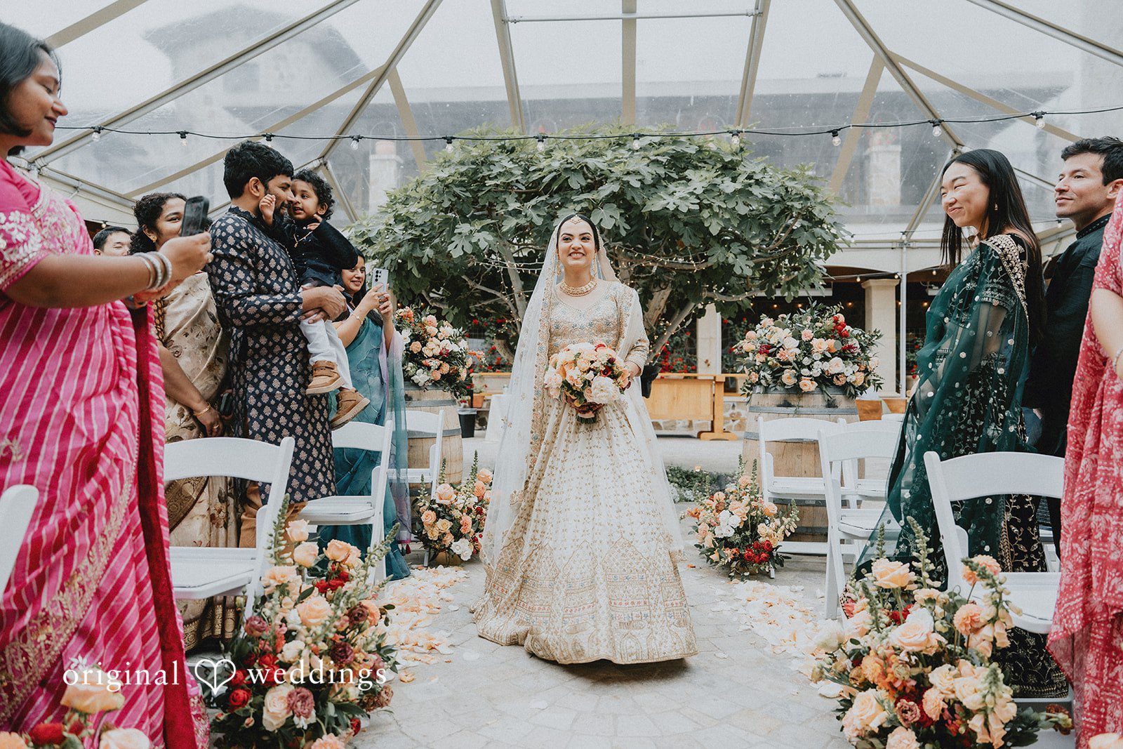 Chandrakant + Sumbul Bride walking toward the ceremony setup outdoors