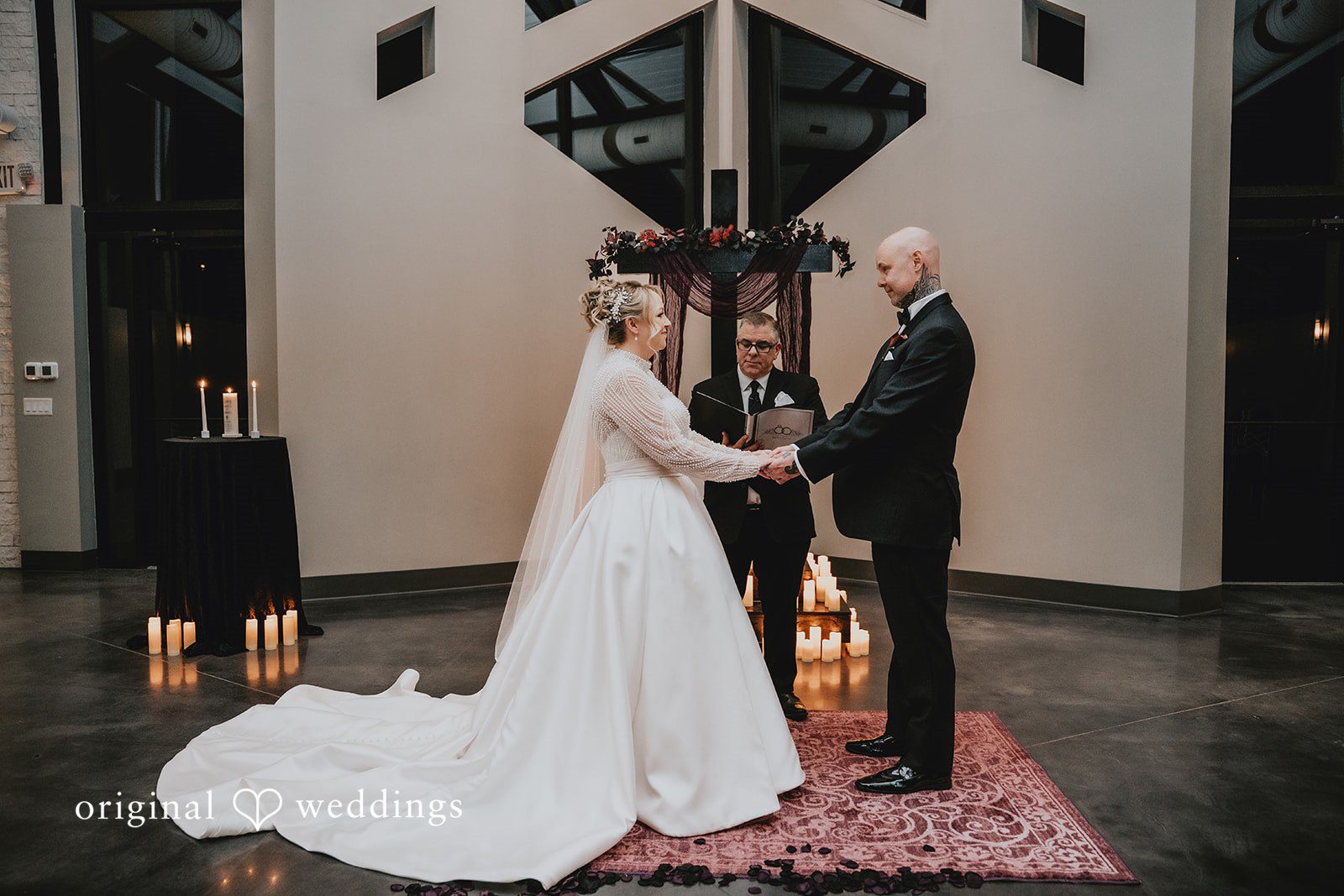 Bride and groom holding hands at the altar.