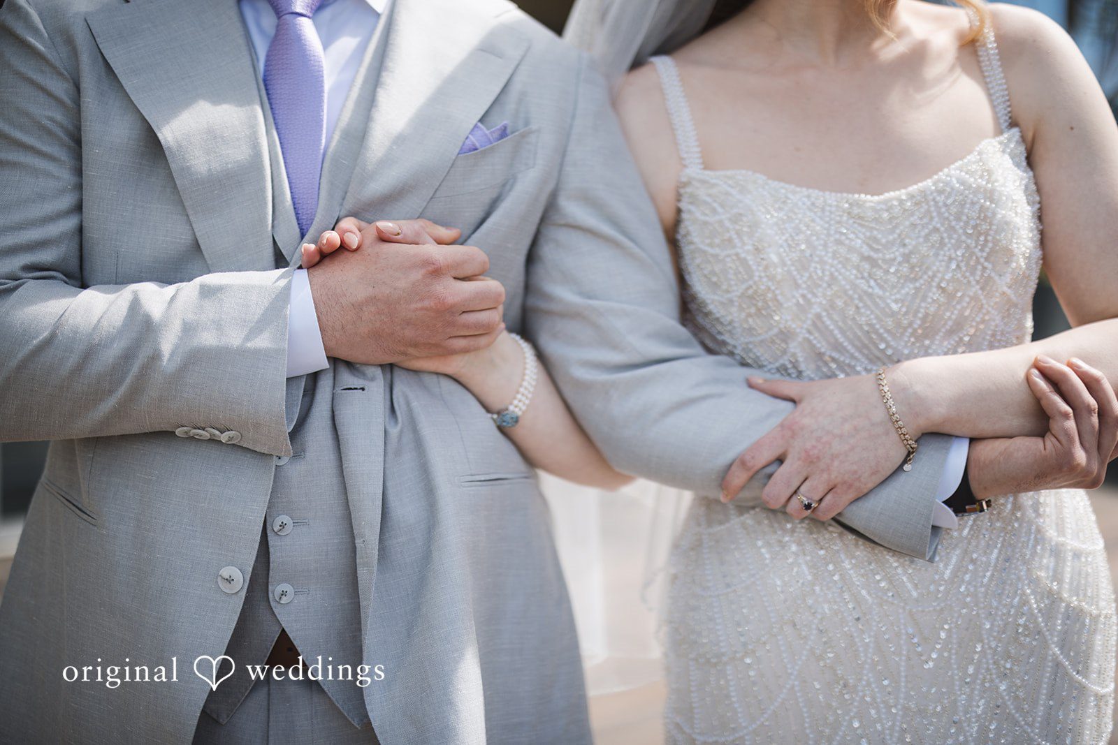 Nicolas + Nicole Close-up of the bride and groom holding hands during the first look