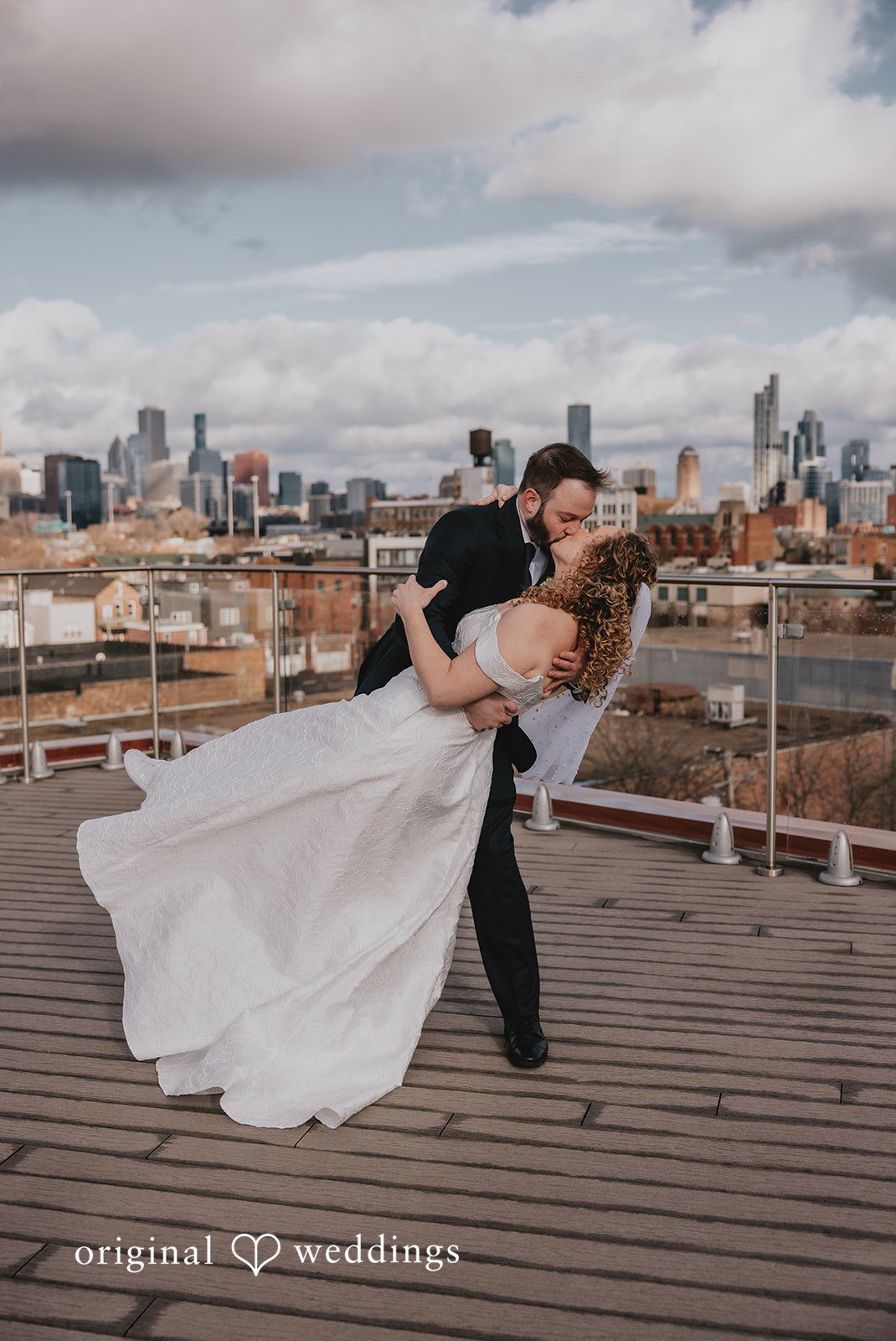 The couple shares a kiss by the rooftop