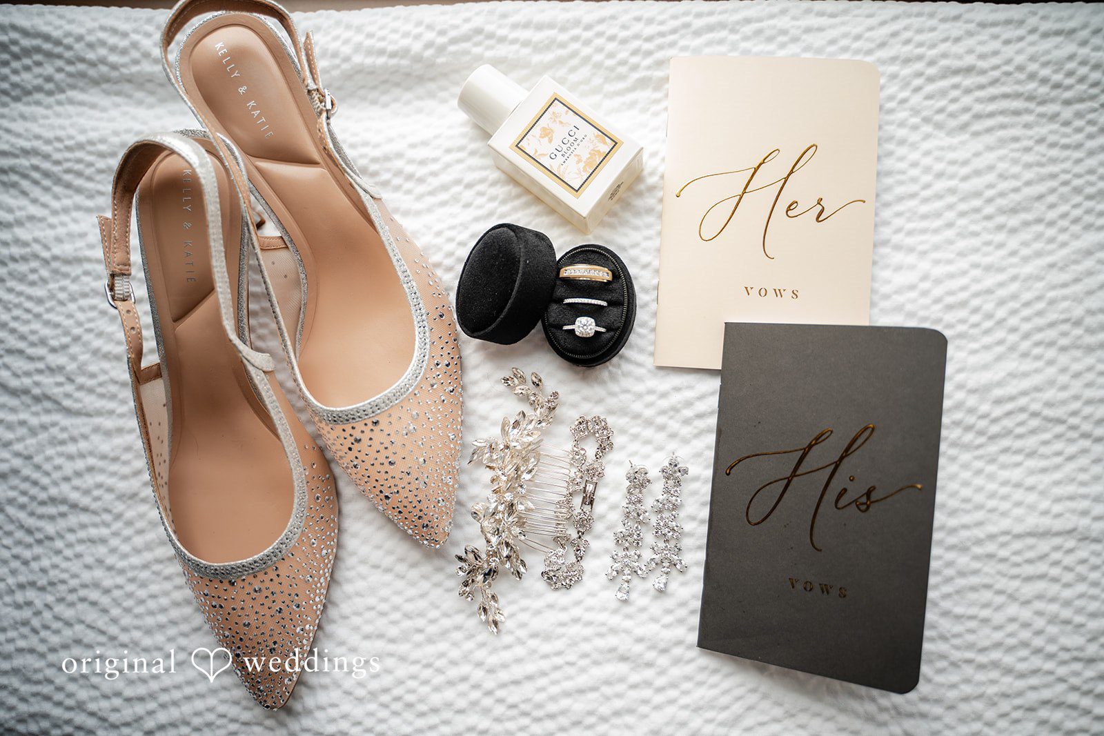 Wedding details including bridal shoes, vow books, and wedding rings styled together
