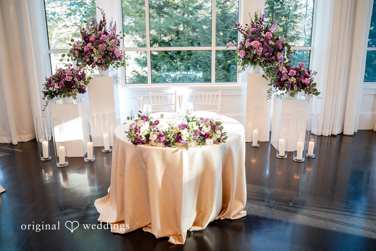 Bride and groom table at the wedding reception decorated with florals and candles