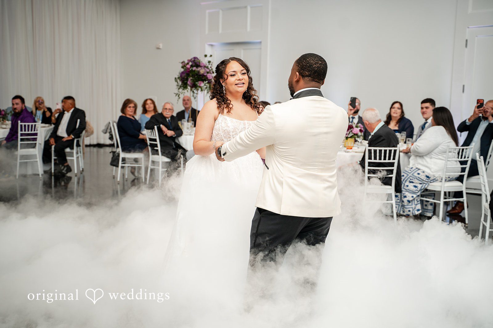 First dance surrounded by romantic fog and soft lighting